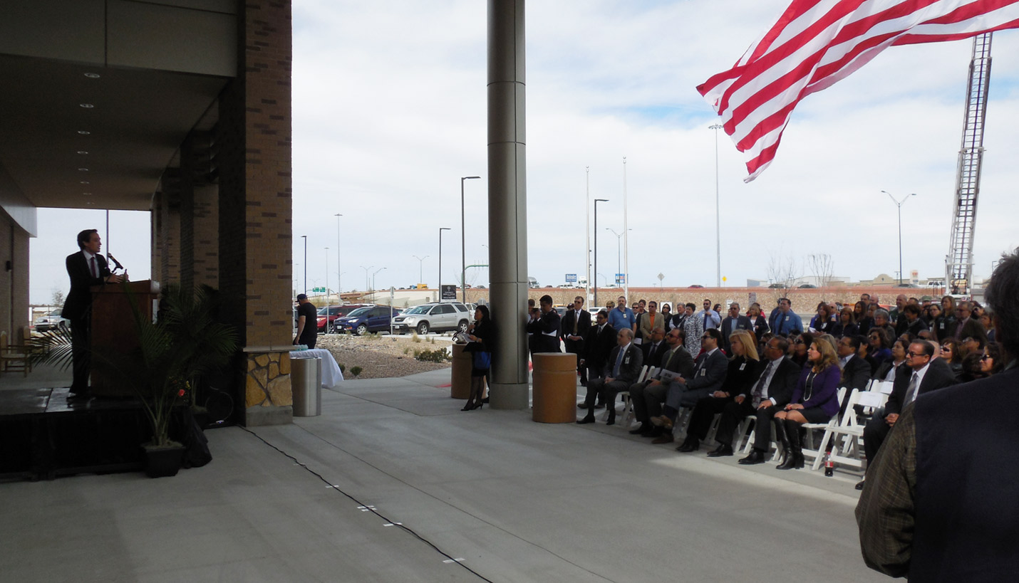 Remarks were made underneath a gigantic American flag hoisted atop a crane. - Page